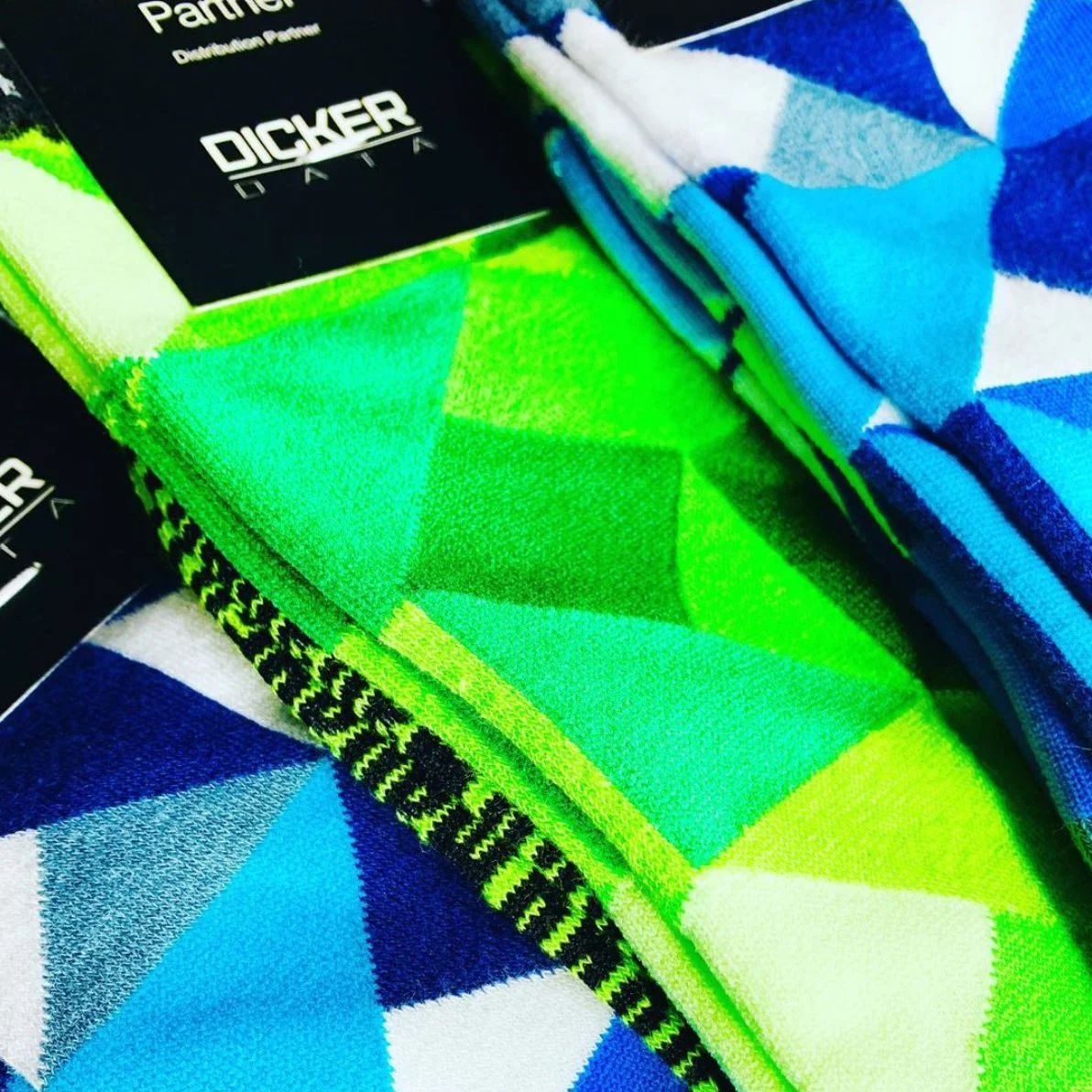 Custom knitted socks with geometric green and blue branding for Dicker Data